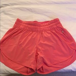 Bright pink lululemon tracker style shorts.